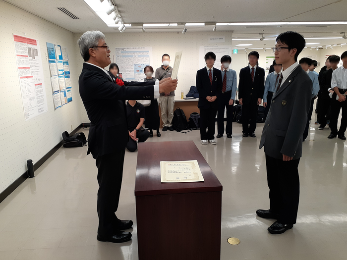 表彰式で表彰を受ける古里君.png